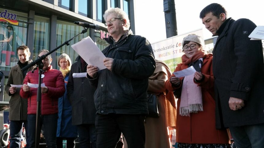 Wolfgang Heintschel beim Vortragen des Gebets der Nationen. Dahinter v.l.n.r.: Andreas Jung, Hans-Peter Storz, Ann-Veruschka Jurisch, Bernd Häusler, Feride Funda G.-Gençaslan (beide verdeckt), Sofie Fiebiger und Oguz Akbudak © UP